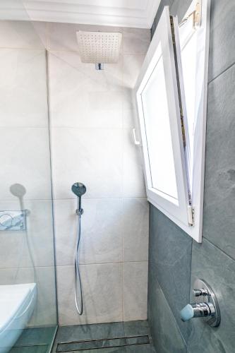 a bathroom with a shower and a sink and a window at Casa Maravilha II in Caniço