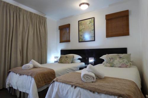 a hotel room with two beds with towels on them at Pennylane Guest House in Ermelo