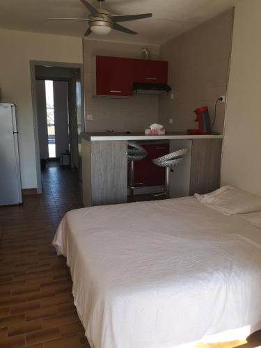 Cet appartement comprend une chambre avec un lit blanc et une cuisine. dans l'établissement Heliopolis F39, au Cap d'Agde
