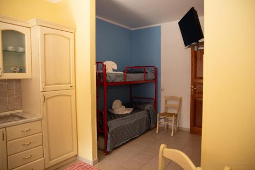 a bedroom with two bunk beds and a kitchen at Camping Village La Pineta in San Vito lo Capo