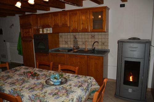 a kitchen with a table and a stove with a fireplace at Maison Élie in Aymavilles