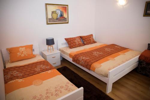 ein Schlafzimmer mit 2 Betten und einem Nachttisch mit einer Lampe in der Unterkunft SkyLine apartments in Mostar