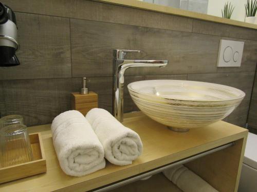a bathroom with a sink and towels on a shelf at Hotel und Gasthof Ritter St. Georg in Erlangen