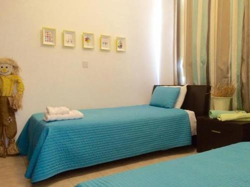 ein Schlafzimmer mit einem Bett mit blauen Laken und einem Teddybären in der Unterkunft Panorama Luxury Villa in Protaras