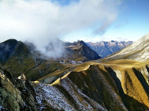 a view of a mountain range with clouds in the sky at Rosa Canina Superior in Sankt Anton am Arlberg