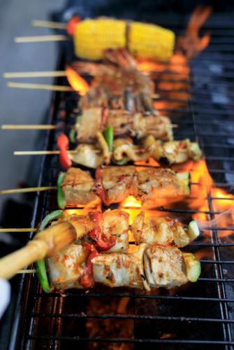a bunch of food cooking on a grill at Hideaway Villas Bali - Uluwatu by Kanaan Hospitality in Uluwatu