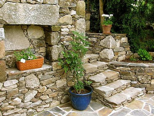 a stone wall with a plant in a blue pot at La Maisonnette in Entraygues-sur-Truyère