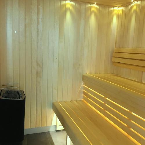 a sauna with wooden walls and a trash can at Hotel KLE, BW Signature Collection in Kaysersberg