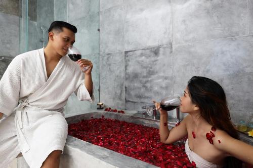 two people drinking wine in a tub of red roses at Hideaway Villas Bali - Uluwatu by Kanaan Hospitality in Uluwatu