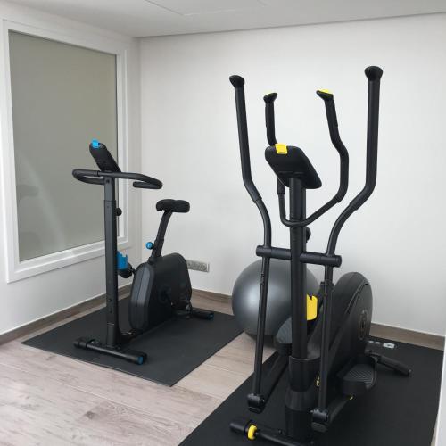 a gym with three exercise bikes and a mirror at Hotel KLE, BW Signature Collection in Kaysersberg