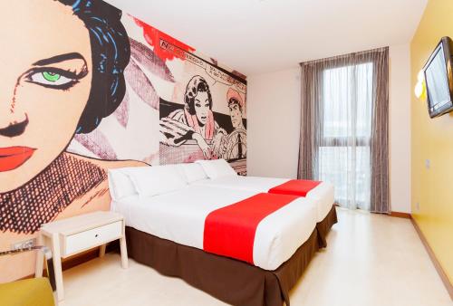 a hotel room with a bed with a painting on the wall at Hotel Gran Bilbao in Bilbao