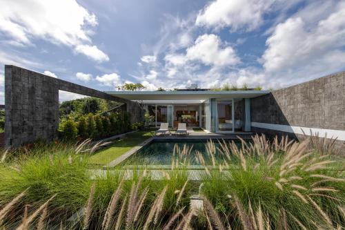 a house with a pool in the middle of a yard at Hideaway Villas Bali - Uluwatu by Kanaan Hospitality in Uluwatu
