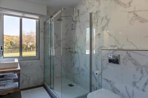 a bathroom with a shower with a glass shower stall at Domaine du Grand Bec in Villerville