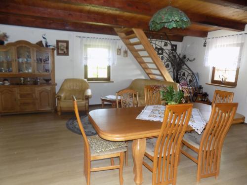 - une salle à manger avec une table et des chaises en bois dans l'établissement Domek na suwalszczyźnie w Taciewie, à Suwałki