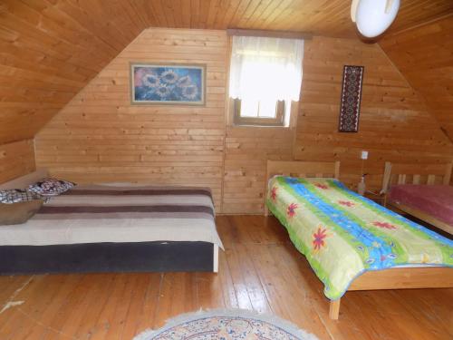 sypialnia z 2 łóżkami w drewnianym domku w obiekcie Domek na suwalszczyźnie w Taciewie w mieście Suwałki