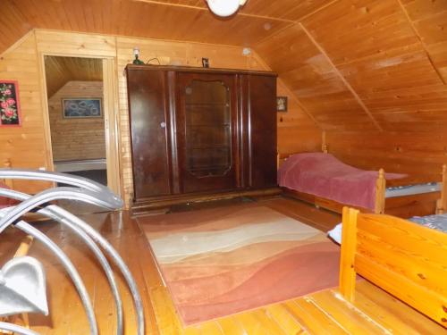 een kleine kamer met een bed in een houten hut bij Domek na suwalszczyźnie w Taciewie in Suwałki