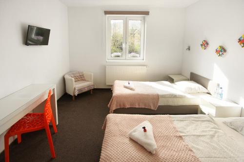 een slaapkamer met twee bedden, een bureau en een raam bij Szekla in Stronie Śląskie