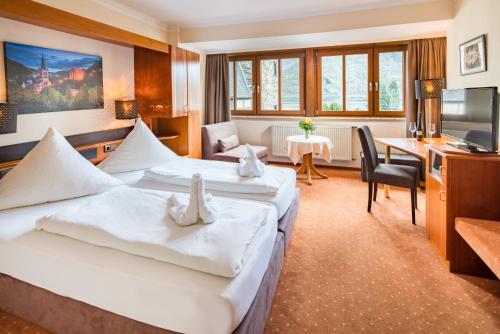 ein Hotelzimmer mit 2 Betten und einem Schreibtisch in der Unterkunft Bacharacher Hof in Bacharach