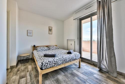 a bedroom with a bed and a large window at Amazing seaview Two-bedroom in Antibes