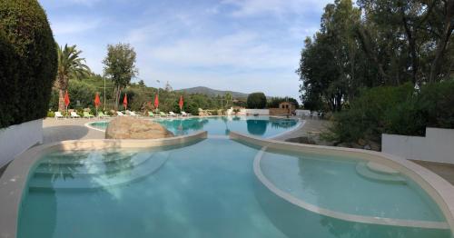 a swimming pool with blue water in a resort at Eden Park Hotel in Marina di Campo