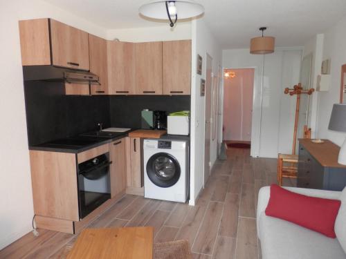 une cuisine avec une machine à laver et un lave-linge dans l'établissement L'Adroit, à Barcelonnette