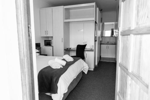 a bedroom with a bed with towels on it at Pennylane Guest House in Ermelo
