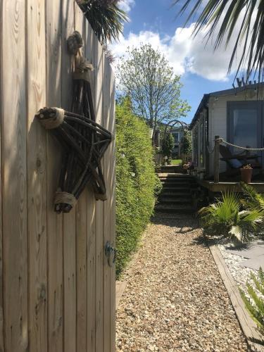 a house with a fence with a bird ornament on it at Stargazy Garden in Hayle