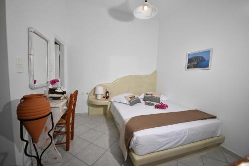 a bedroom with a bed and a lamp at Philoxenia Hotel & Studios in Perissa