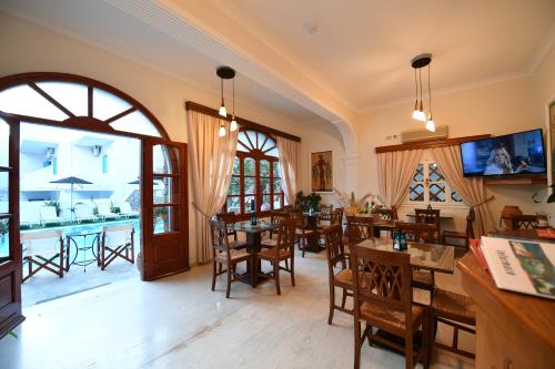 a living room with tables and chairs and a kitchen at Philoxenia Hotel & Studios in Perissa