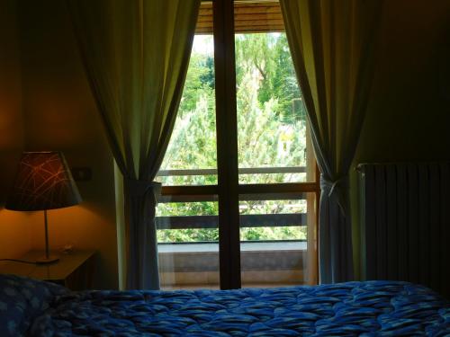 a bedroom with a bed and a large window at Villa Russo in Castel di Sangro