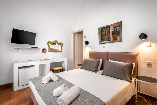 a bedroom with two beds and a tv on the wall at Casa De La Sera in Rhodes Town