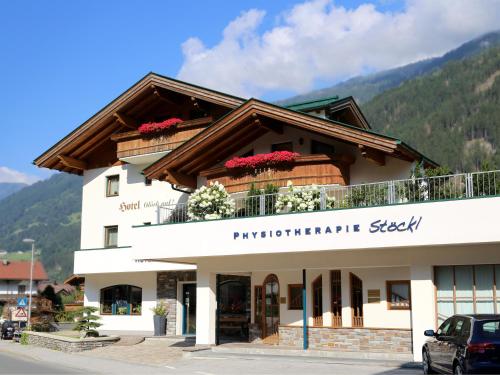 a building with a balcony with flowers on it at Hotel & Suites Glück Auf in Mayrhofen