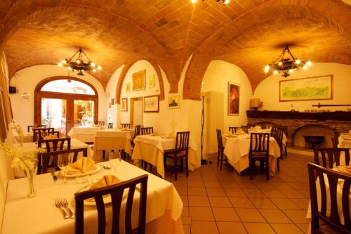 a restaurant with tables and chairs in a room at Locanda Il Pino in San Gimignano