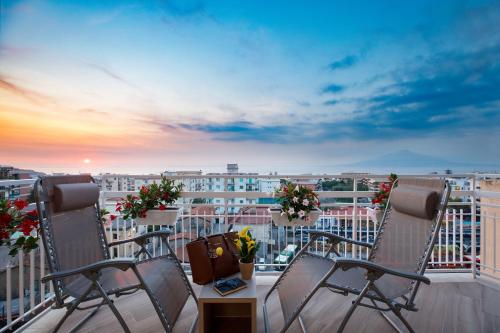 a balcony with chairs and a view of a city at Le Muse Suite in Sorrento