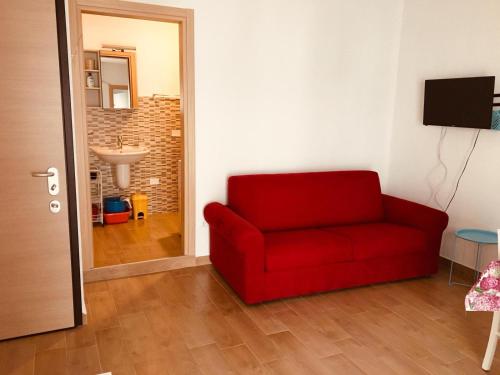 a red couch in a living room with a bathroom at CAV Mameli in Dorgali