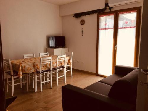 a dining room with a table and chairs and a television at CAV Mameli in Dorgali