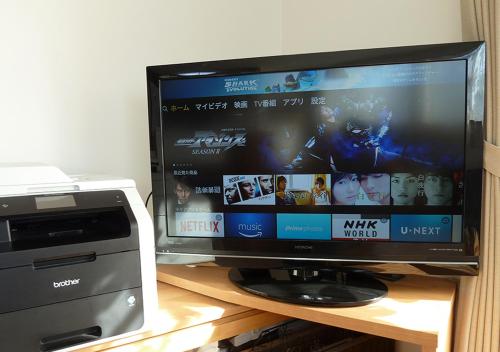a flat screen tv sitting on a desk with a printer at Kanaloa Funabashi in Funabashi