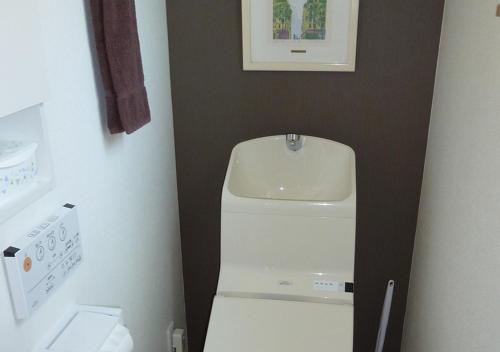 a small bathroom with a sink and a white refrigerator at Kanaloa Funabashi in Funabashi