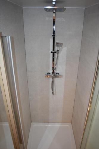 a shower with a shower head in a bathroom at Boatyard View in Sandwich