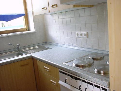 a kitchen with a stove and a sink at Arber Ferienwohnungen Friedl in Bayerisch Eisenstein
