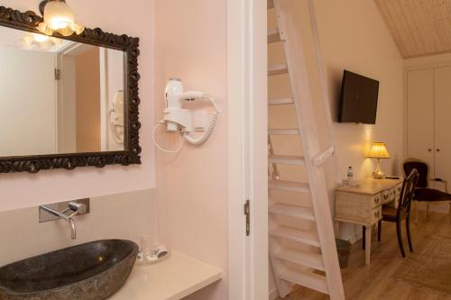 a bathroom with a sink and a mirror at Aires da Serra Hotel in Torres Novas