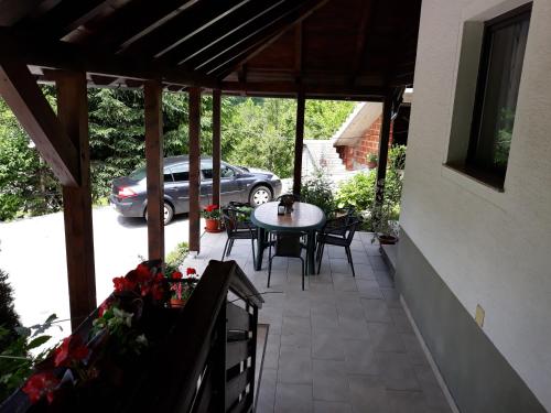 une terrasse avec une table, des chaises et une voiture dans l'établissement House Zlatko, à Selište Drežničko