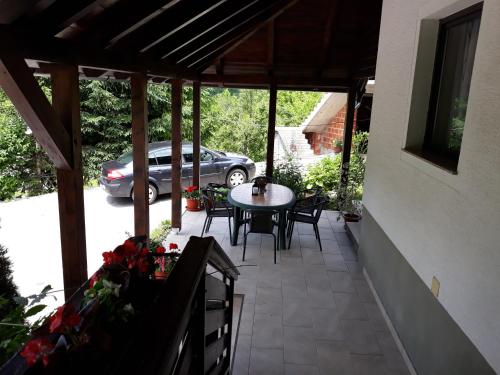 un patio con una mesa y sillas y un coche en House Zlatko, en Selište Drežničko