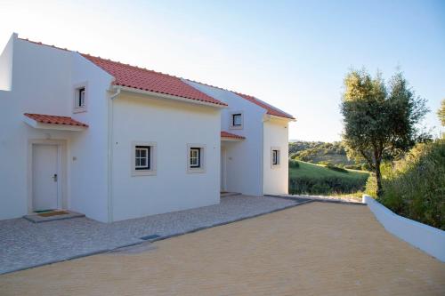 a white house with a driveway at Aires da Serra Hotel in Torres Novas