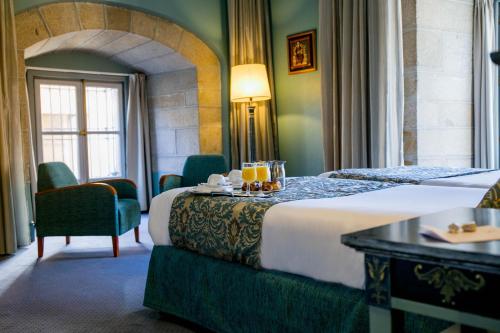 a hotel room with a bed with drinks on it at Palacio de los Velada in Avila