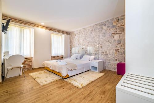 - une chambre avec un lit et un mur en briques dans l'établissement Idassa Atrium rooms, à Zadar