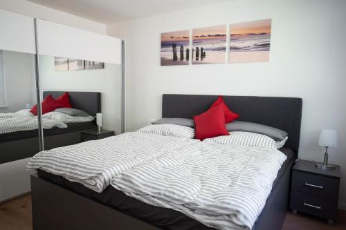 ein Schlafzimmer mit einem großen Bett mit roten Kissen in der Unterkunft Modernes 2-RoomApartment in Wuppertal