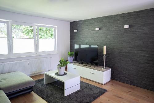 ein Wohnzimmer mit einem Flachbild-TV an einer Backsteinwand in der Unterkunft Modernes 2-RoomApartment in Wuppertal