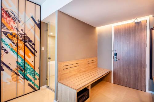 a dressing room with a bench and a door at Hotel Amber Pattaya in Pattaya Central