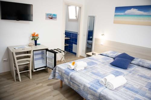 sypialnia z łóżkiem, biurkiem i telewizorem w obiekcie B&B Il Viaggiatore w mieście Tortolì